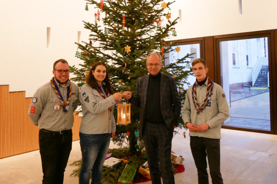 Eine Pfadfindergruppe bei der Übergabe des Friedenslichts in den Räumlichkeiten des Hessischen Landtags vor einem Weihnachtsbaum.