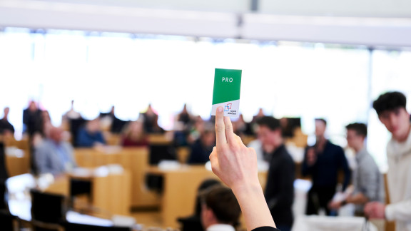 Hand hält Karte mit "Pro" hoch
