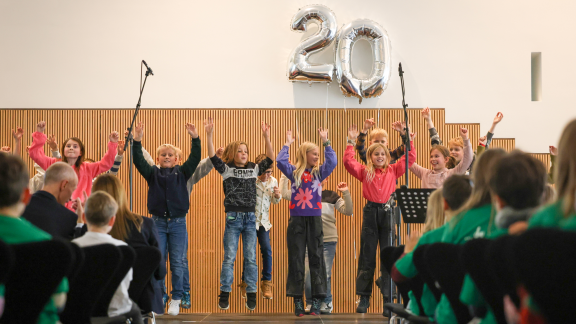 Kinder springen auf einer Bühne in die Höhe