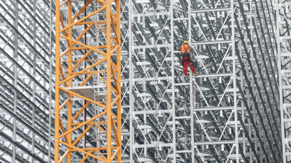 Person klettert an Baugerüst