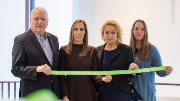 Präsidiumsmitglieder halten grünes Band