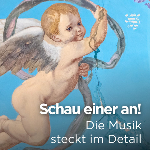 Ein Engel ist im Bild zu sehen. Er ist Teil der Deckenmalereien im Musiksaal. Der Schriftzug "Schau einer an! Die Musik steckt im Detail" ist zu lesen.