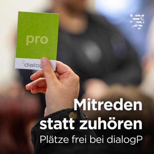 Eine Hand hält ein Schild in die Höhe, das mit den Wörtern "PRO" und "dialogP" bedruckt ist. Der folgende Text ist zu lesen: "Mitreden statt zuhören. Plätze frei bei dialogP".