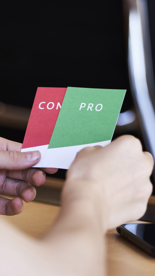 Ein Schüler hält eine rote und eine grüne Karte in den Händen.