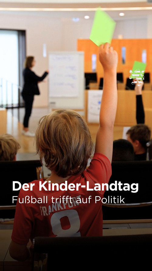 Ein Junge hält eine grüne Karte in die Höhe und stimmt während eines Planspiels im Hessischen Landtag ab.