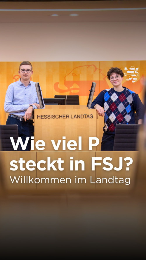 Die neuen FSJler Marius und Charlotte lehnen am Rednerpult im Plenarsaal des Hessischen Landtages. Der Schriftzug "Wie viel P steckt in FSJ? Willkommen im Landtag" ist zu lesen.
