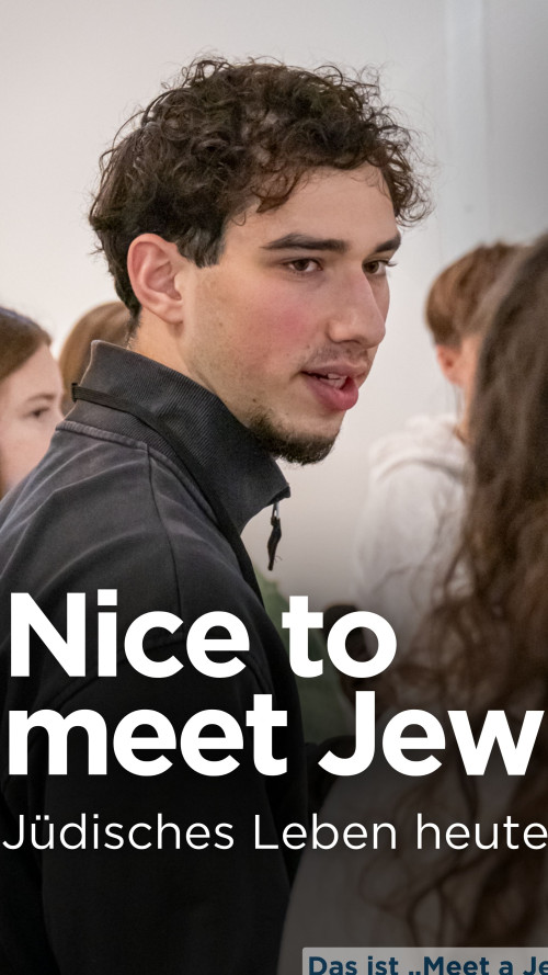 Ein Teilnehmer des Begegnungsprojekts "Meet a Jew" ist im Bild zu sehen. Er spricht mit einer Schülerin.