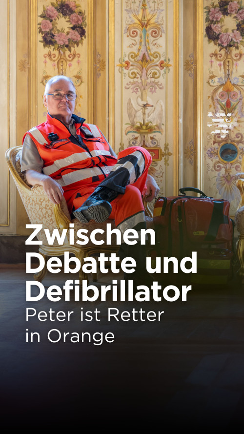 Rettungssanitäter Peter sitzt auf einem Sessel im prunkvollen Wiesbadener Stadtschloss. Er trägt seine Rettungssanitäter-Uniform. Neben ihm auf dem Boden steht sein Notfallrucksack.