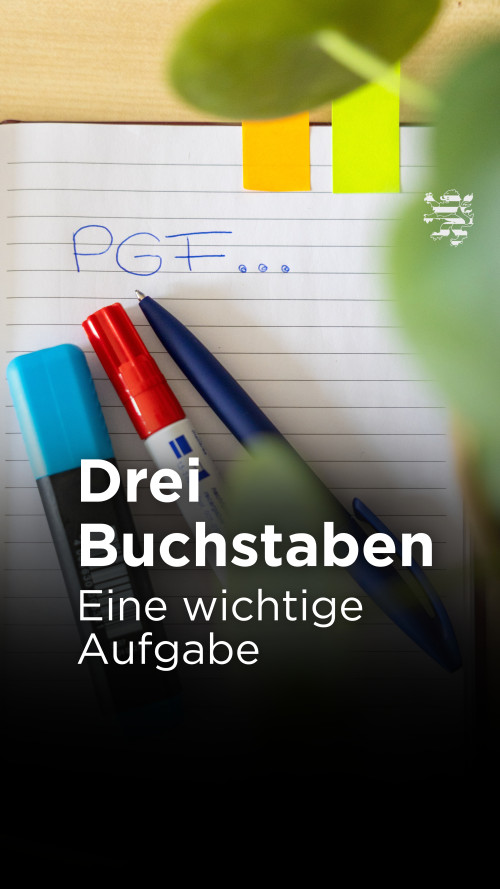 Auf einem Blatt Papier wurden die Buchstaben "PGF" notiert. Drei Stifte und die Blätter einer Pflanze sind zu erkennen. Der folgende Schriftzug ist zu lesen: "Drei Buchstaben. Eine wichtige Aufgabe".