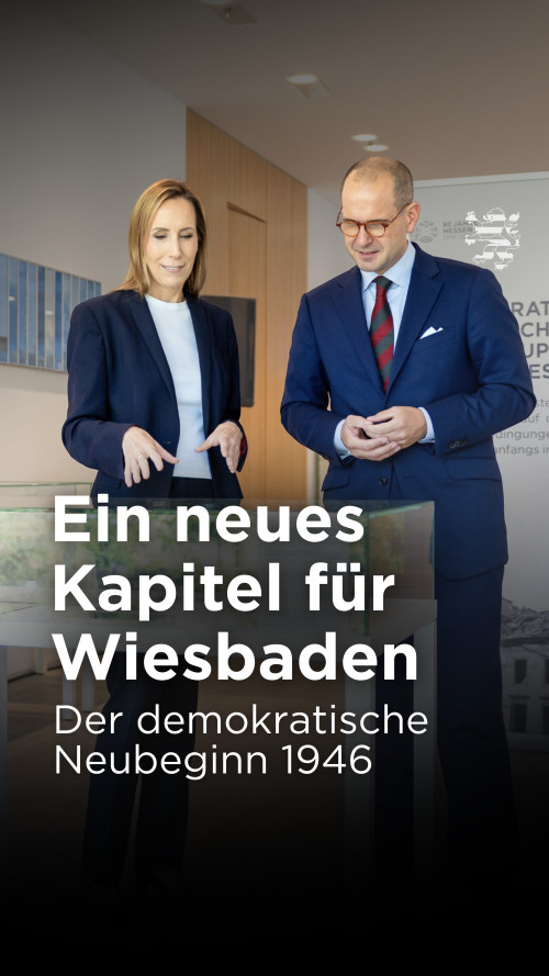 Landtagspräsidentin Wallmann und der Leiter des Wiesbadener Stadtarchivs, Dr. Quadflieg, sind im Bild zu sehen. Sie betrachten eine Vitrine. Der folgende Schriftzug ist zu lesen: "Ein neues Kapitel für Wiesbaden. Der demokratische Neubeginn 1946".