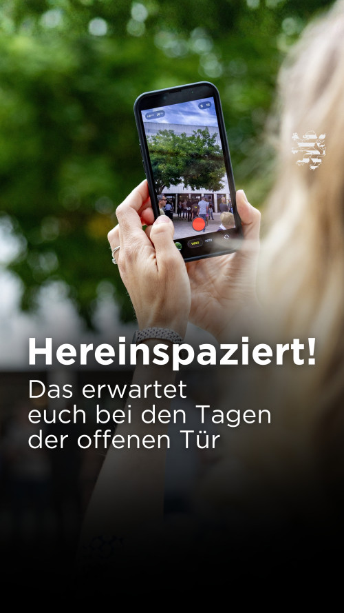 Eine Person hält ein Handy in der Hand. Durch den Bildschirm ist der Innenhof des Landtages zu sehen.