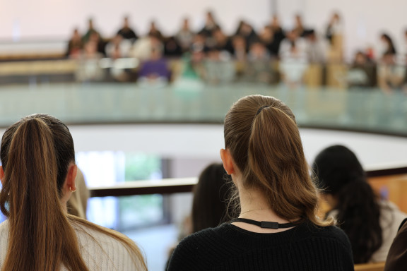 Zwei junge Frauen wohnen von der Besuchergalerie aus einer Plenarsitzung bei.