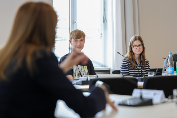 Zwei Teilnehmende im Gespräch mit Landtagspräsidentin Astrid Wallmann