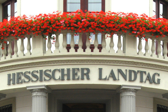 Balkon des Stadtschlosses, der am Geländer mit roten Blumen geschmückt ist. Darunter steht "Hessischer Landtag".