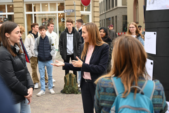 Landtagspräsidentin Astrid Wallmann lässt sich die Bilder von Schülerinnen und Schülern zeigen.