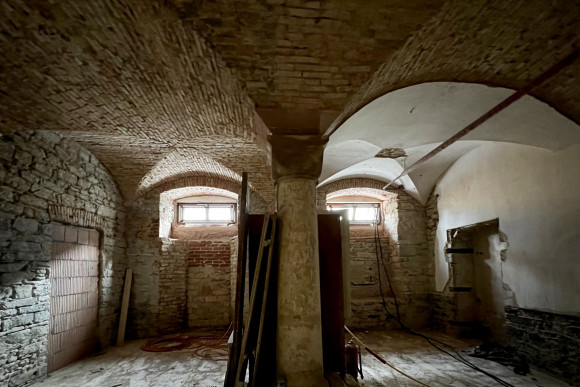 Ein Kellergewölbe des Stadtschlosses. Im Hintergrund sind zwei kleine Fenster.