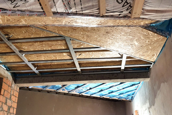 Blick vom obersten Podest im östlichen Treppenhaus gegen die Dachhaut mit ihren komplexen Verschneidungen der Dachflächen.