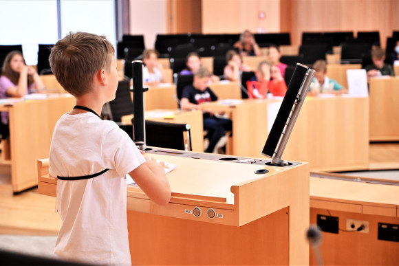 Ein Grundschüler hält am Redepult des Hessischen Landtages eine Rede.