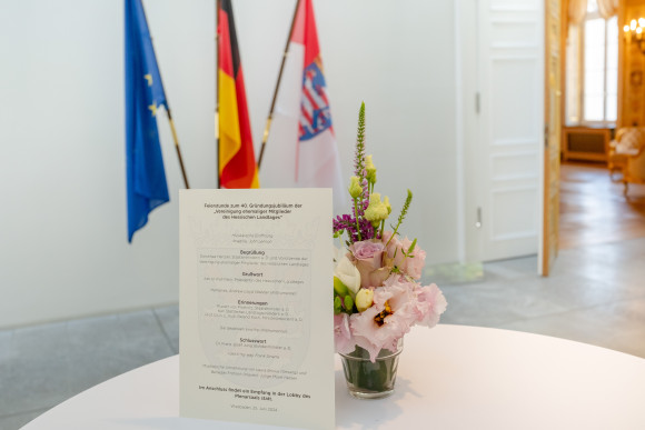 Programmzettel und Blumenschmuck auf Tisch