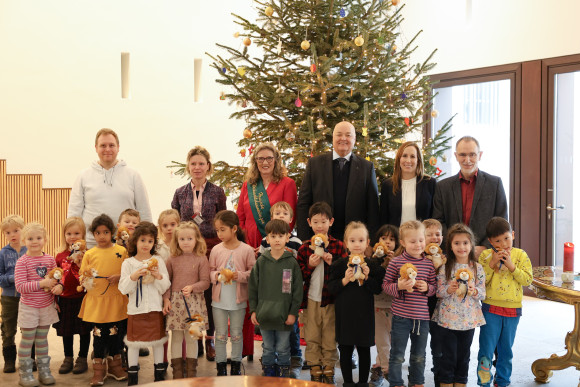 Gruppenbild mit Kindern vorm Weihnachtsbaum