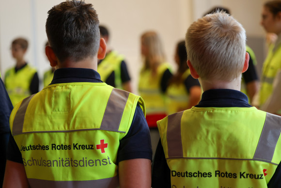 Kinder in gelben Westen von hinten