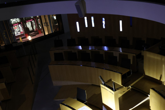 Blick in den dunklen Plenarsaal mit Rednerpult