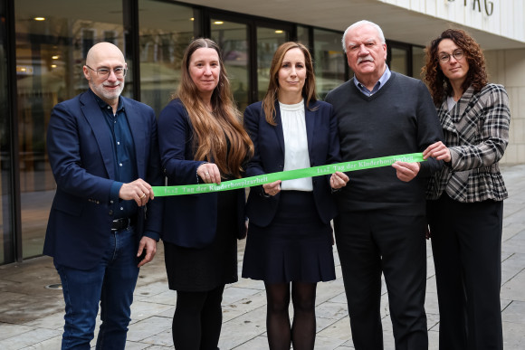 Landtagspräsidentin und Vizepräsidenten halten ein grünes Band