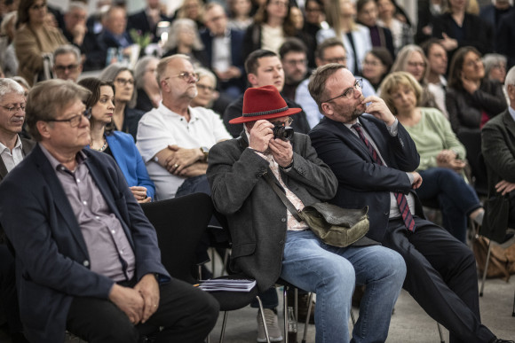 Gäste sitzen in Stuhlreihen