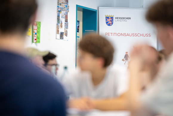 Schüler vor Petitionsbanner