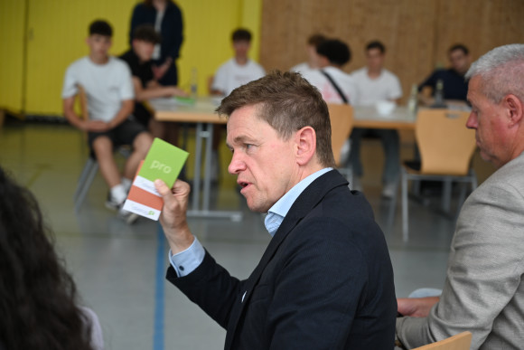 André Stolz hält zwei Abstimmungszettel hoch