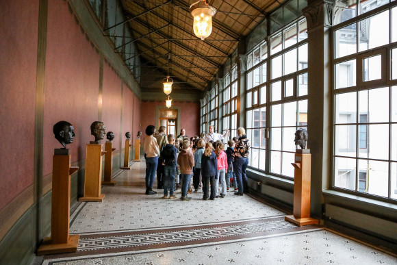 hess.landtag-foto-hupfeld-5852.jpg Eine Gruppe Kinder schaut sich Porträtbüsten im Wintergarten an.
