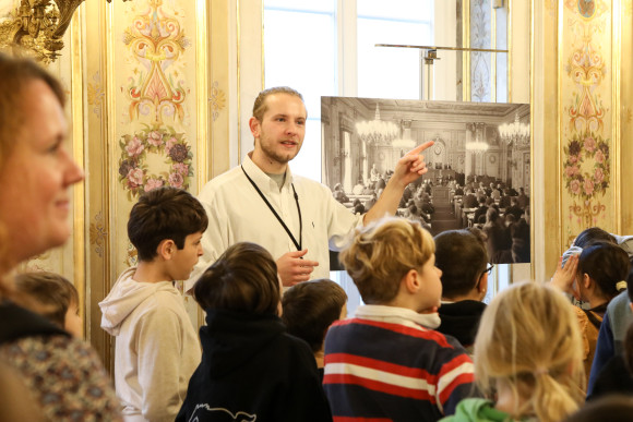 hess.landtag-foto-hupfeld-5915.jpg Gästeführer erklärt einer Gruppe Kinder den Musiksaal
