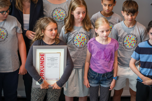 Schülerinnen und Schüler halten Urkunde