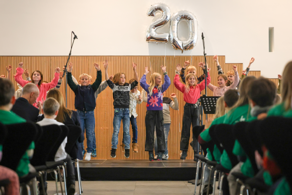 20 Jahre „Musikalische Grundschulen“ Kinder springen auf einer Bühne in die Höhe