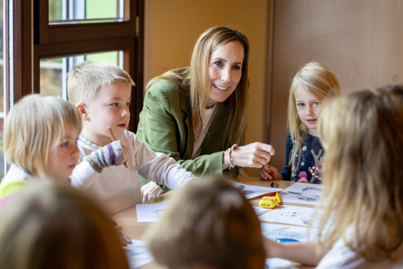 Landtagspräsidentin und Kinder malen am Tisch