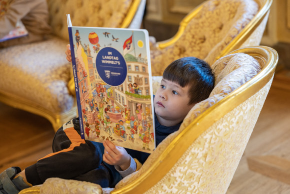 Kind blättert im Wimmelbuch