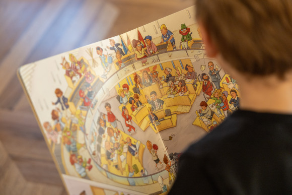 Kind schaut sich Wimmelbuch an