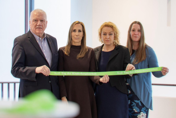 Präsidiumsmitglieder halten grünes Band