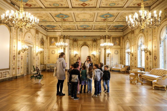 Kinder mit Lehrerinnen im Musiksaal