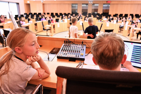 Eine Schülerin und ein Schüler bedienen beim Planspiel "Der Kinder-Landtag" die Mikrofonanlage.