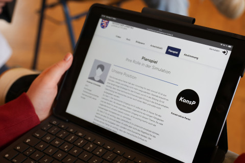 Eine Schülerin hält ein Tablet in Händen. 