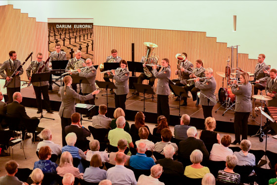Der Heeresmusikkorps Kassel spielt auf einer Bühne vor Publikum.