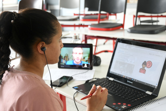 Eine Schülerin nimmt mit Laptop und Tablet am Online-Planspiel teil