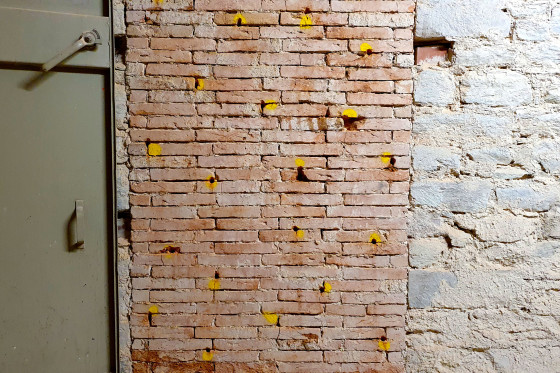 Eine Wand mit gelben Markierungen im Stadtschloss.