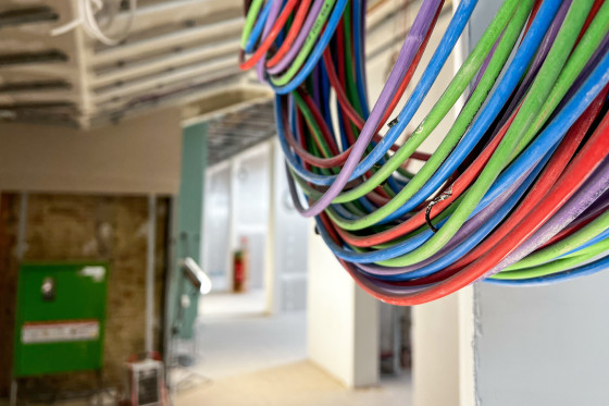 Kabel mit verschiedenen Farben hängen von der Wand.