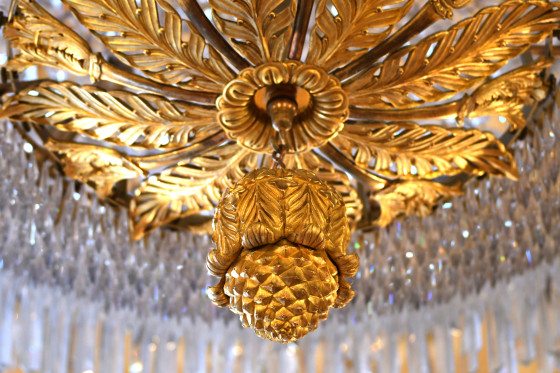 Nahaufnahme des goldenen Kronleuchters im Kuppelsaal des Wiesbadener Stadtschlosses.