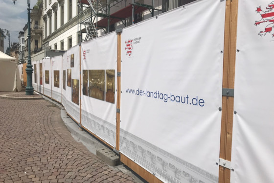 Schlosssanierung: Am Bauzaun informieren Banner über das Vorhaben