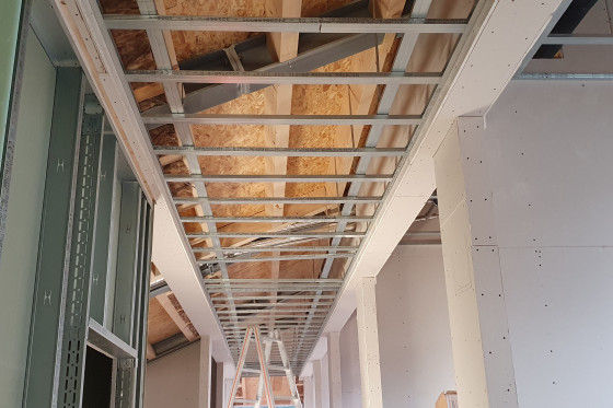 Die Unterkonstruktion der Deckenabhängung im Flur des Ostflügels ist fertig und kann nach Einbau der Technik mit Gipsplatten beplankt werden. 