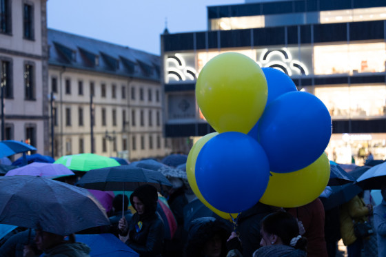 Blaue und gelbe Luftballons schweben über den Teilnehmenden der Kundgebung. Sie symbolisieren die Farben der ukrainischen Flagge.