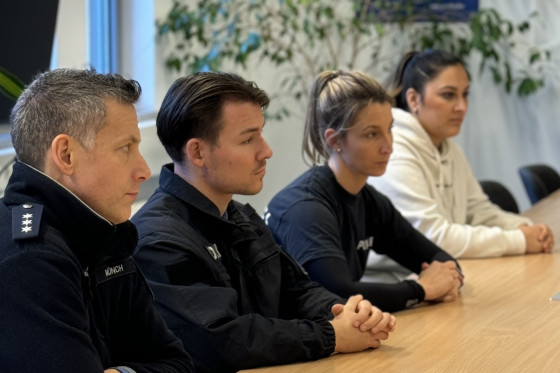 Polizeikräfte sitzen an Tisch